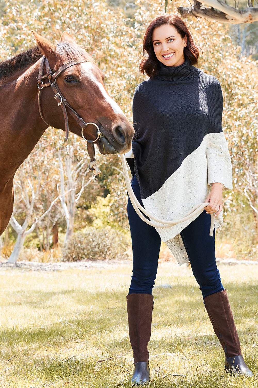 Model Perrie wearing The Panel Knit Poncho in colour Charcoal (Black), from the front, showing the whole outfit