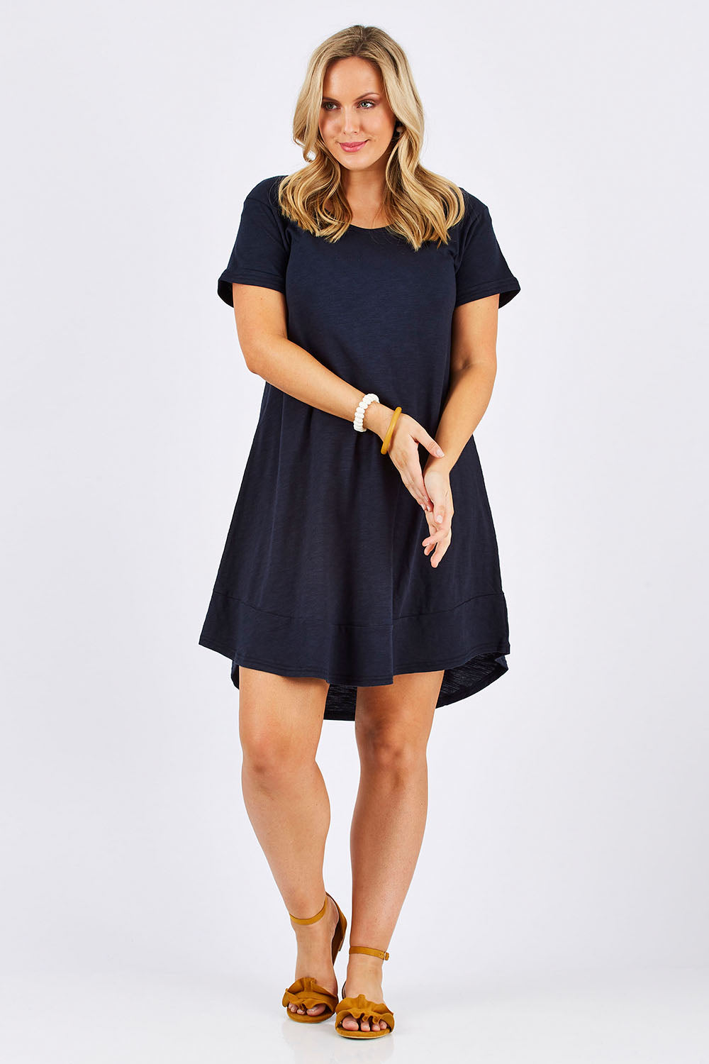 Model Jess wearing size 12 of The Swing Dress in colour Navy (Blue), from the front, showing the whole outfit