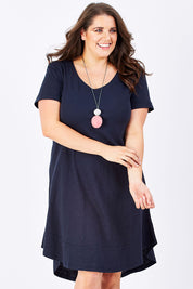 Model Mae wearing size 16 of The Swing Dress in colour Navy (Blue), from the front, cropped image
