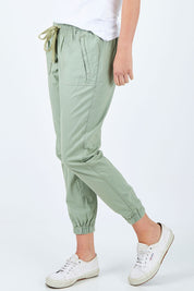 Model Chelsea wearing size 10 of The Weekender Pant in colour Khaki (Green), from the front, cropped image
