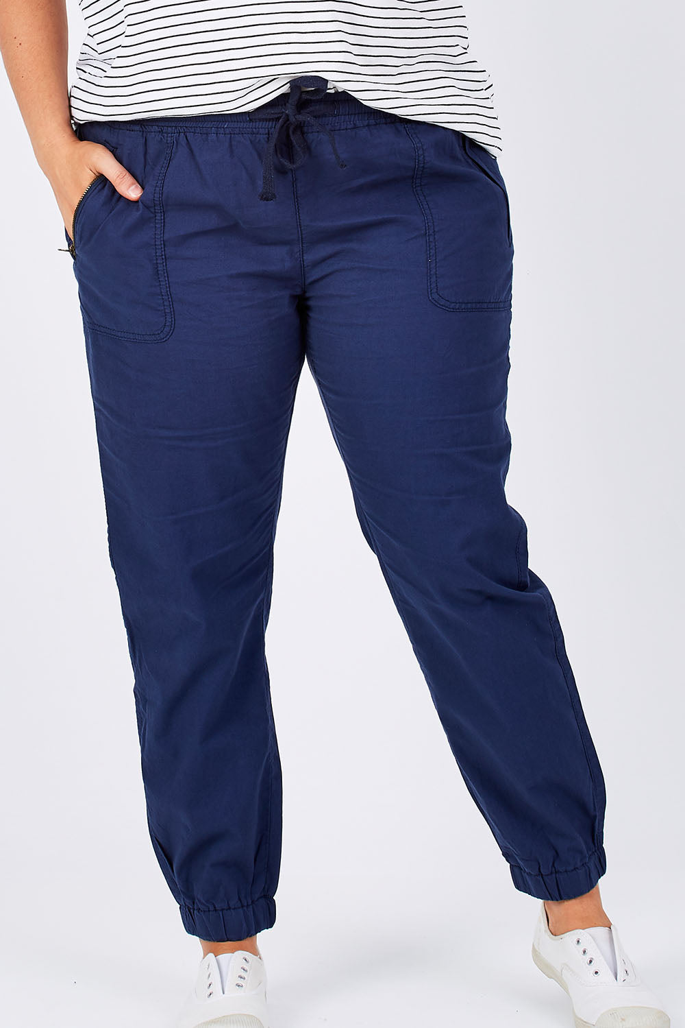 Model Mae wearing size 16 of The Weekender Pant in colour Navy (Blue), from the front, cropped image
