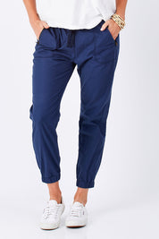 Model Perrie wearing size 10 of The Weekender Pant in colour Navy (Blue), from the front, cropped image