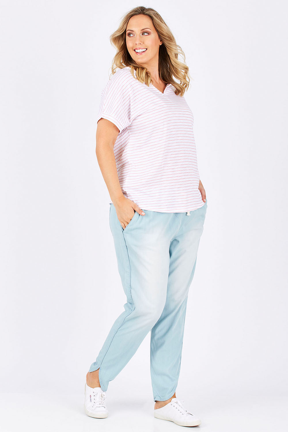 Model Jess wearing size 14 of The Chambray Curved Hem Pant in colour Chambray (Blue), from the front, showing the whole outfit