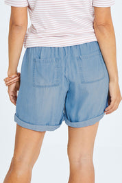Model Cara wearing size 10 of The Weekender Chambray Short in colour Blue (Blue), from the back