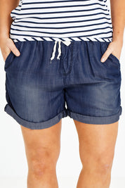 Model Laura wearing size 14 of The Weekender Chambray Short in colour Mediumblue (Blue), from the front, cropped image