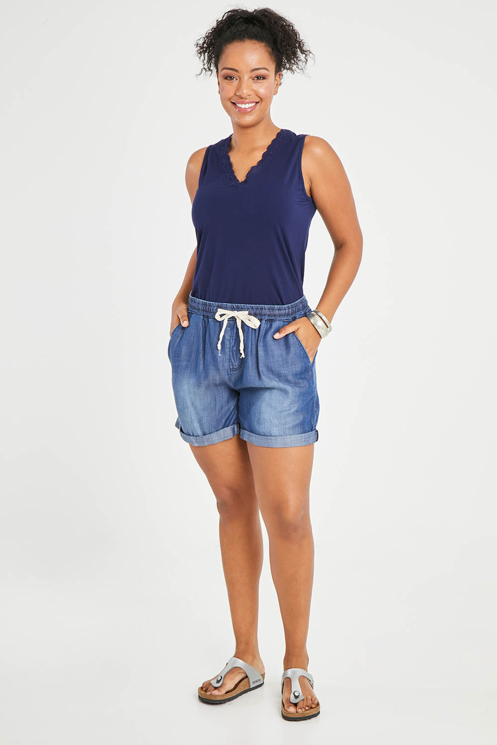Model Noli wearing size 14 of The Weekender Chambray Short in colour Mediumblue (Blue), from the front, showing the whole outfit