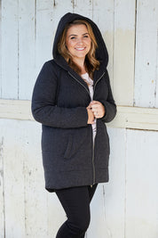 A model wearing size 14 of The Luxe Puffer Jacket in colour Charcoal (Black), from the front, cropped image