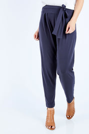 Model Chelsea wearing size 10 of The Comfort Pant in colour Charcoal (Grey), from the front, cropped image