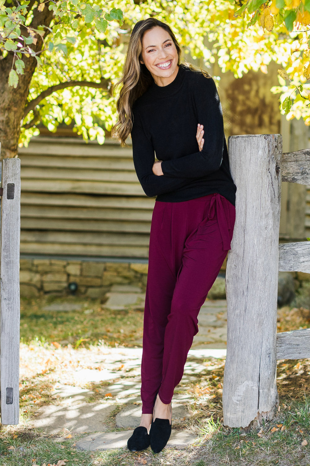 Model Amanda wearing size 10 of The Comfort Pant in colour Port (Red), from the front, showing the whole outfit