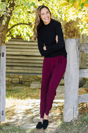Model Amanda wearing size 10 of The Comfort Pant in colour Port (Red), from the front, showing the whole outfit