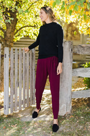 Model Amanda wearing size 10 of The Comfort Pant in colour Port (Red), from the front, showing the whole outfit