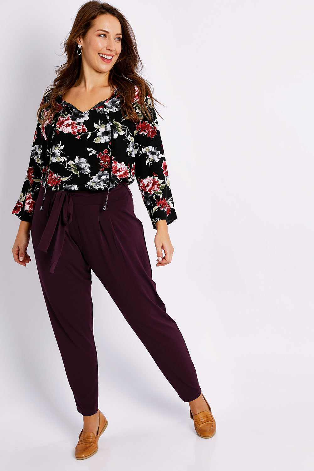 Model Jessica wearing size 14 of The Comfort Pant in colour Port (Red), from the front, showing the whole outfit