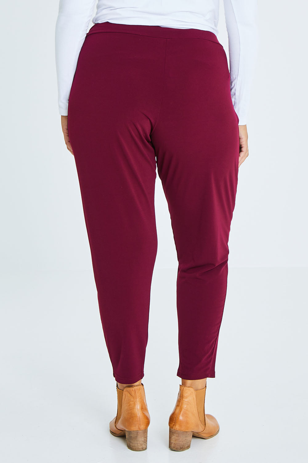 Model Palatina wearing size 16 of The Comfort Pant in colour Port (Red), from the back