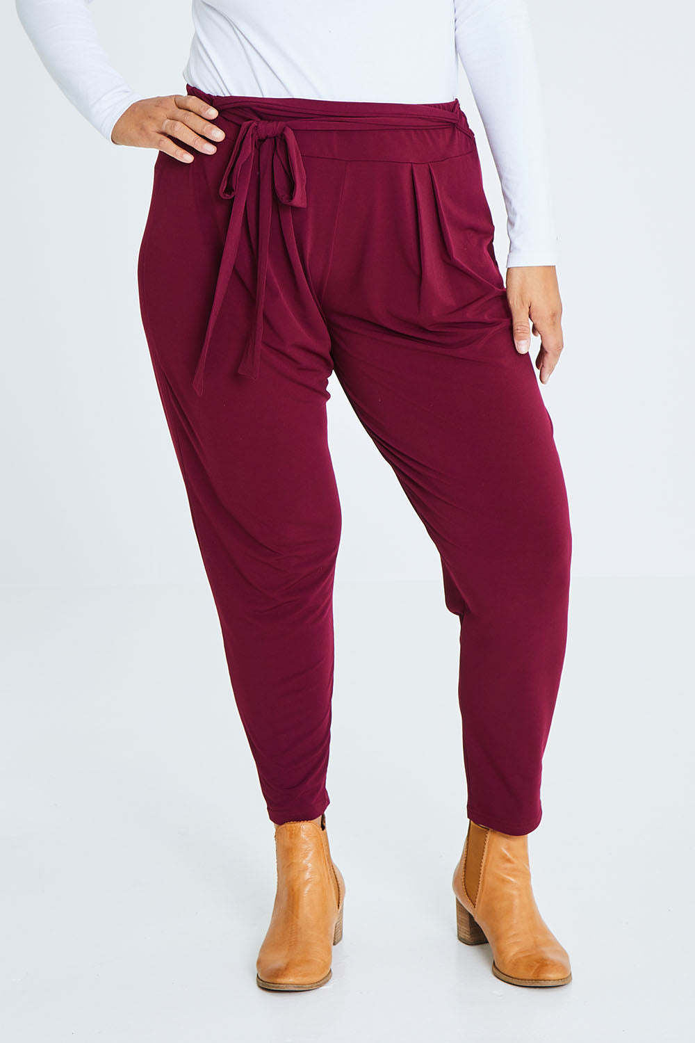 Model Palatina wearing size 16 of The Comfort Pant in colour Port (Red), from the front, cropped image