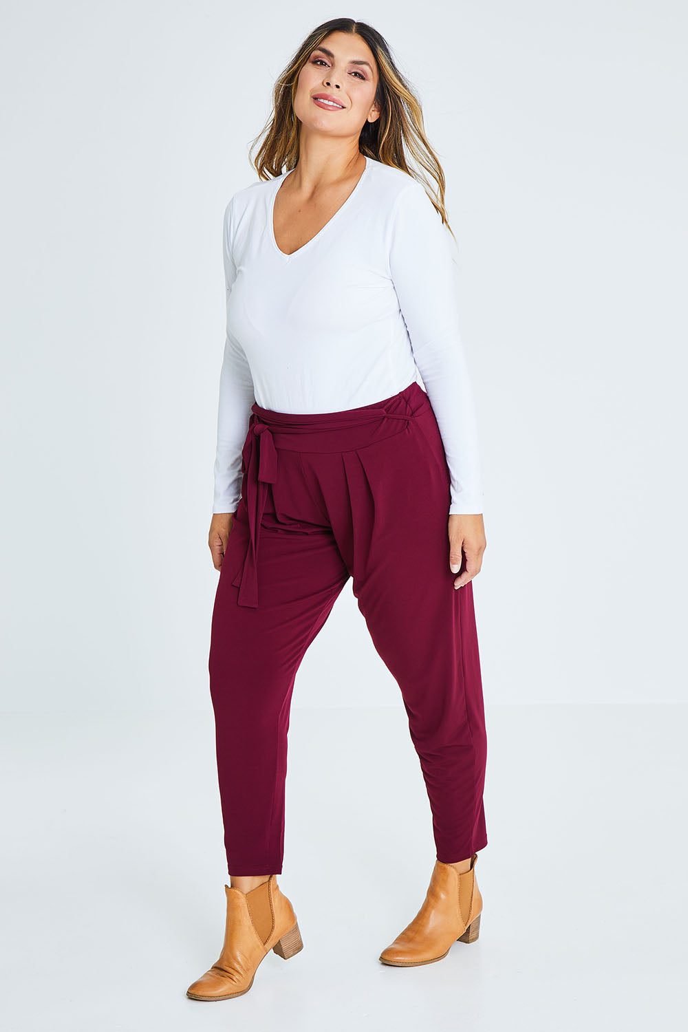 Model Palatina wearing size 16 of The Comfort Pant in colour Port (Red), from the front, showing the whole outfit