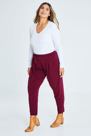 Model Palatina wearing size 16 of The Comfort Pant in colour Port (Red), from the front, showing the whole outfit