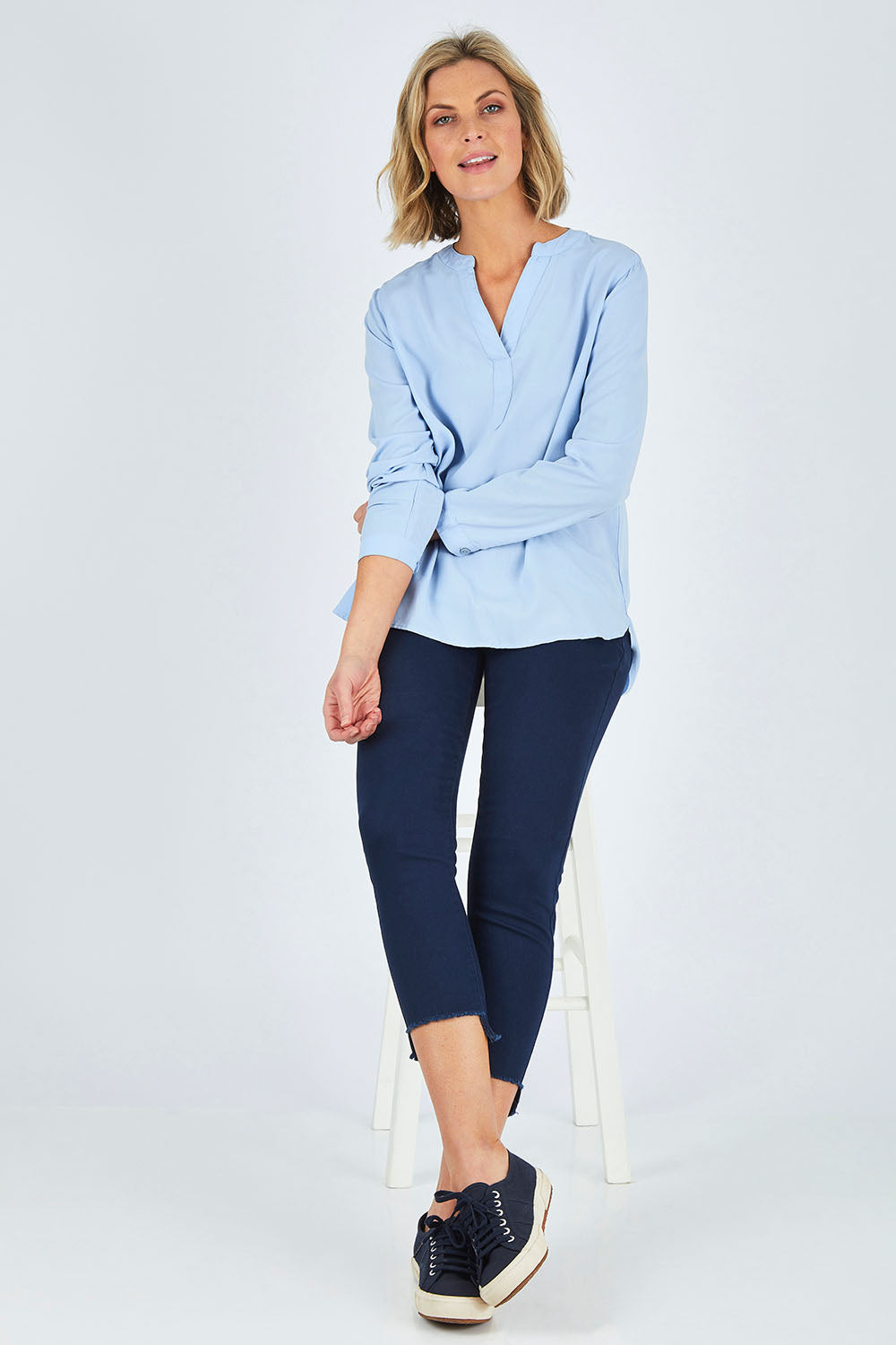 Model Chelsea wearing size 10 of The Skinny Step Hem Jean in colour Blue (Blue), from the front, showing the whole outfit