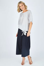 Model Chelsea wearing size 10 of The Luxe Tie Front Top in colour Silver (Grey), from the front, showing the whole outfit