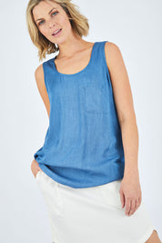 Model Chelsea wearing size 10 of The Pocket Tank Top in colour Chambray (Blue), from the front, cropped image