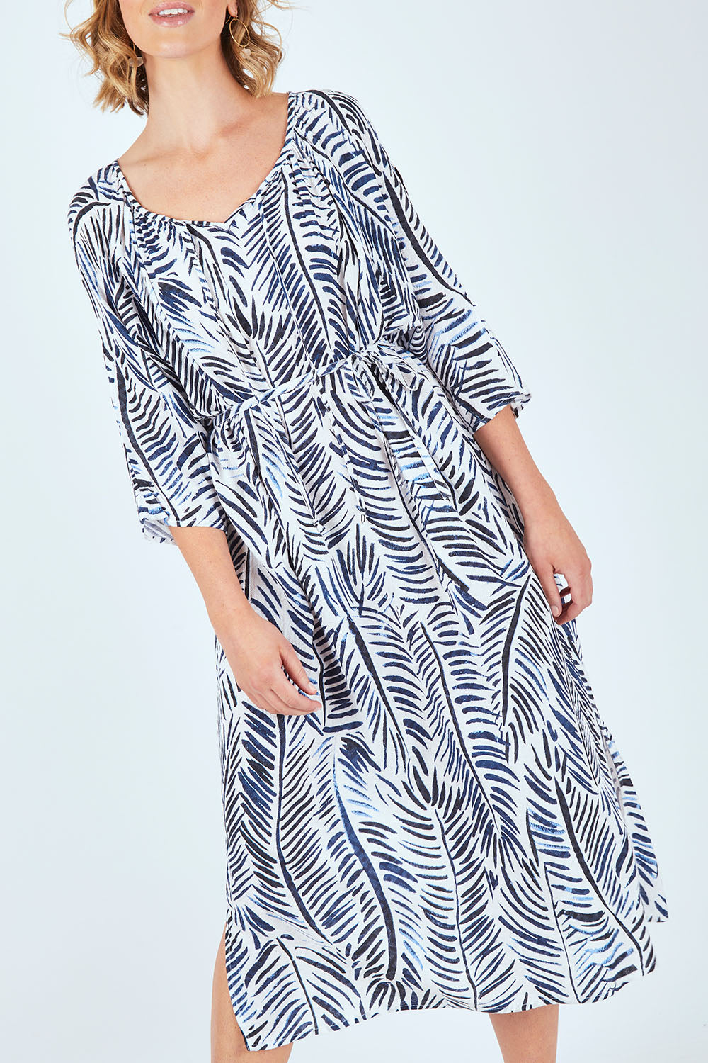 Model Chelsea wearing size 10 of The Open Shoulder Dress in colour Print (Blue), from the front, cropped image