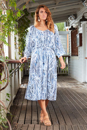 Model Laura wearing size 14 of The Open Shoulder Dress in colour Print (Blue), from the front, showing the whole outfit