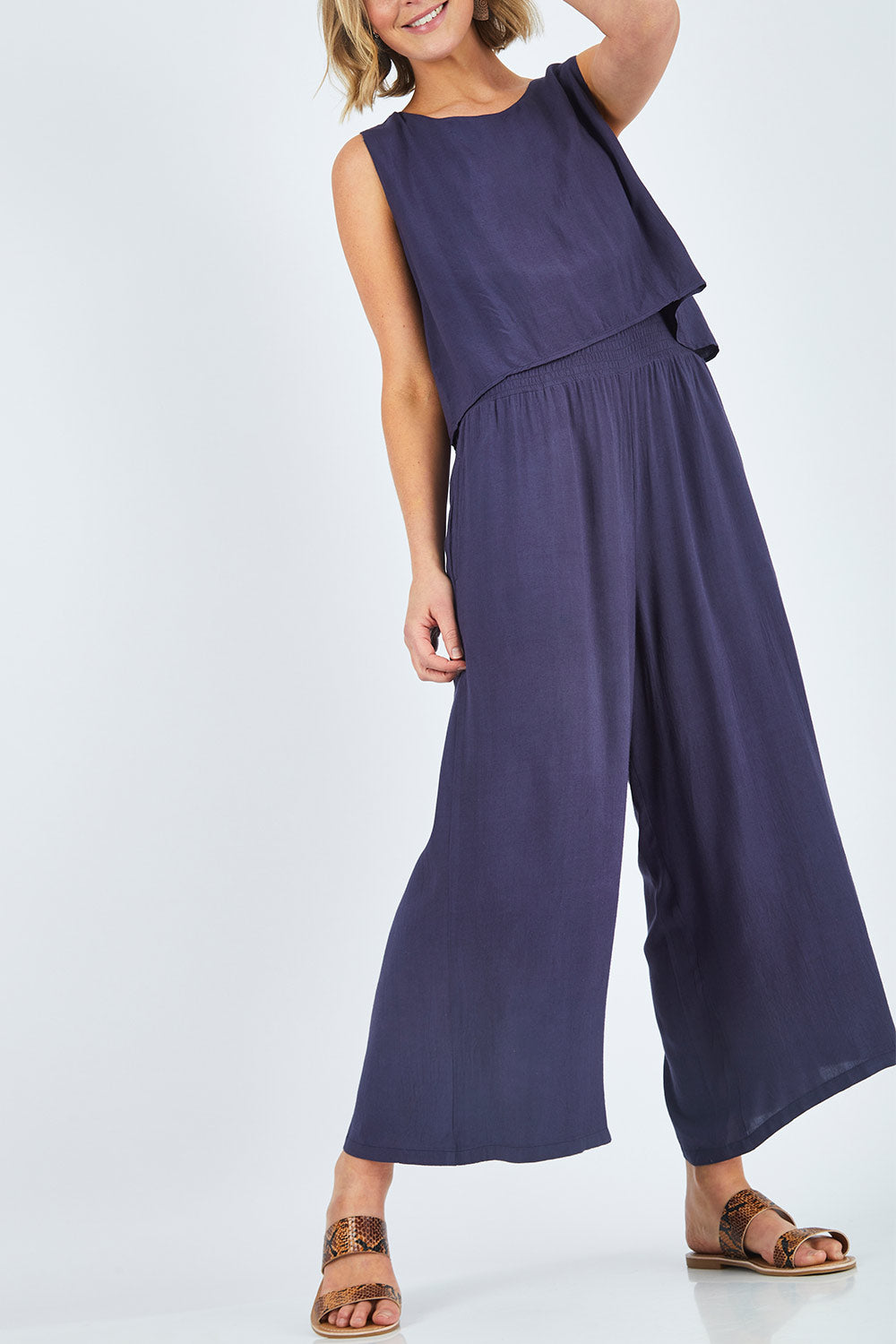 Model Chelsea wearing size 10 of The Overlay Jumpsuit in colour Navy (Blue), from the front, cropped image