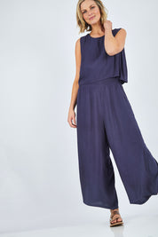 Model Chelsea wearing size 10 of The Overlay Jumpsuit in colour Navy (Blue), from the front, showing the whole outfit