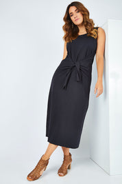 Model Laura wearing size 14 of The Tie Waist Tank Dress in colour Black (Black), from the front, showing the whole outfit
