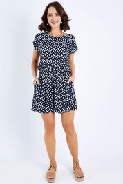 Model Andrea wearing size 10 of The Printed Tie Waist Playsuit in colour Multiprint (Black), from the front, showing the whole outfit