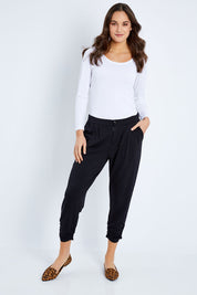 Model Elhana wearing size 10 of The Winter Best Seller Pant in colour Black (Black), from the front, showing the whole outfit