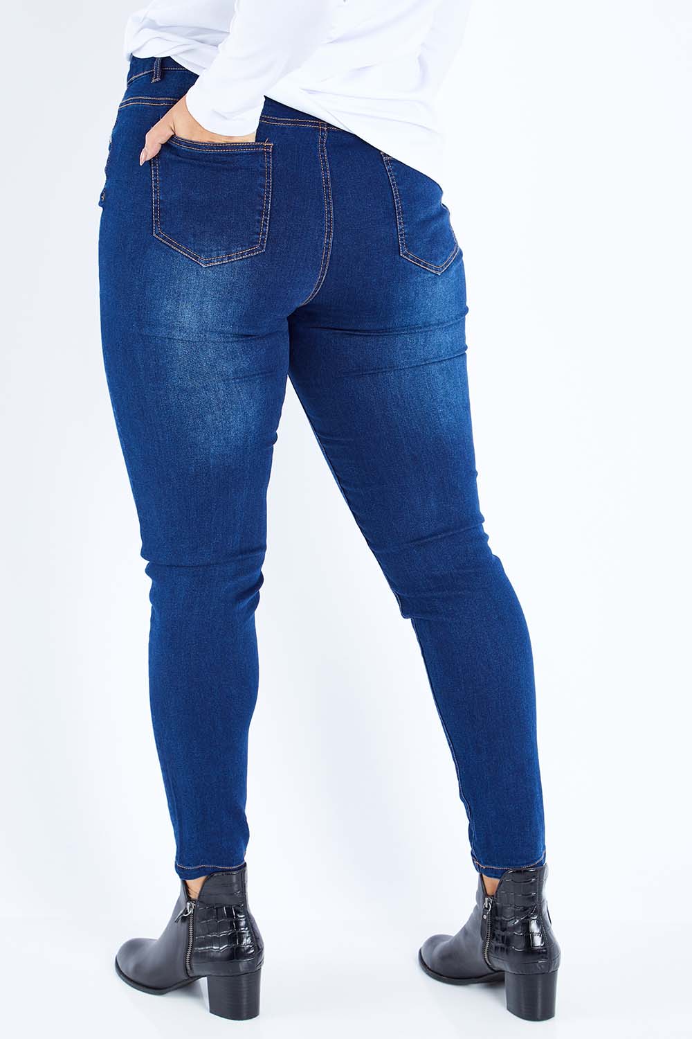 Model Sasha-Lee wearing size 16 of The Mid Rise Skinny Jean in colour Denim (Blue), from the back