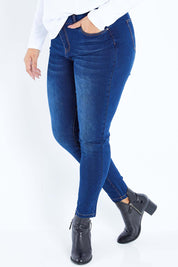 Model Sasha-Lee wearing size 16 of The Mid Rise Skinny Jean in colour Denim (Blue), from the front, cropped image