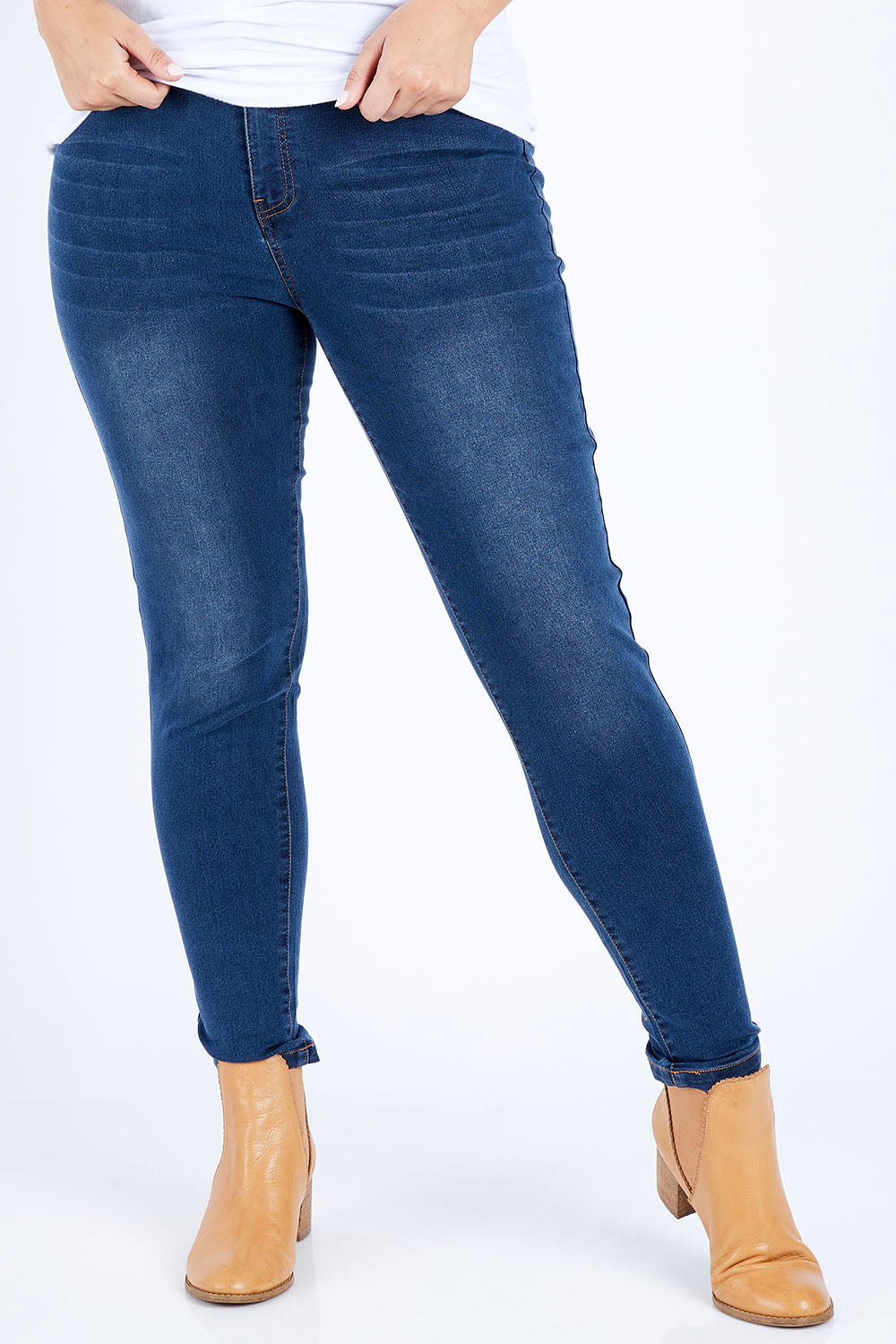Model Jess wearing size 14 of The Mid Rise Skinny Jean in colour Drkdenim (Blue), from the front, cropped image