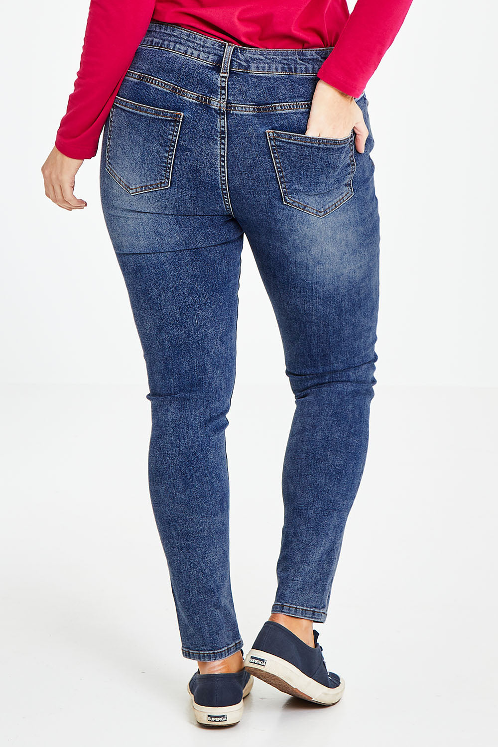 Model Laura wearing size 14 of The Mid Rise Skinny Jean in colour Washdenim (Blue), from the back