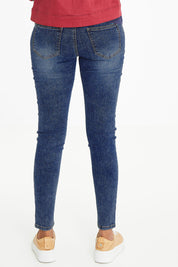 Model Schanez wearing size 10 of The Mid Rise Skinny Jean in colour Washdenim (Blue), from the back