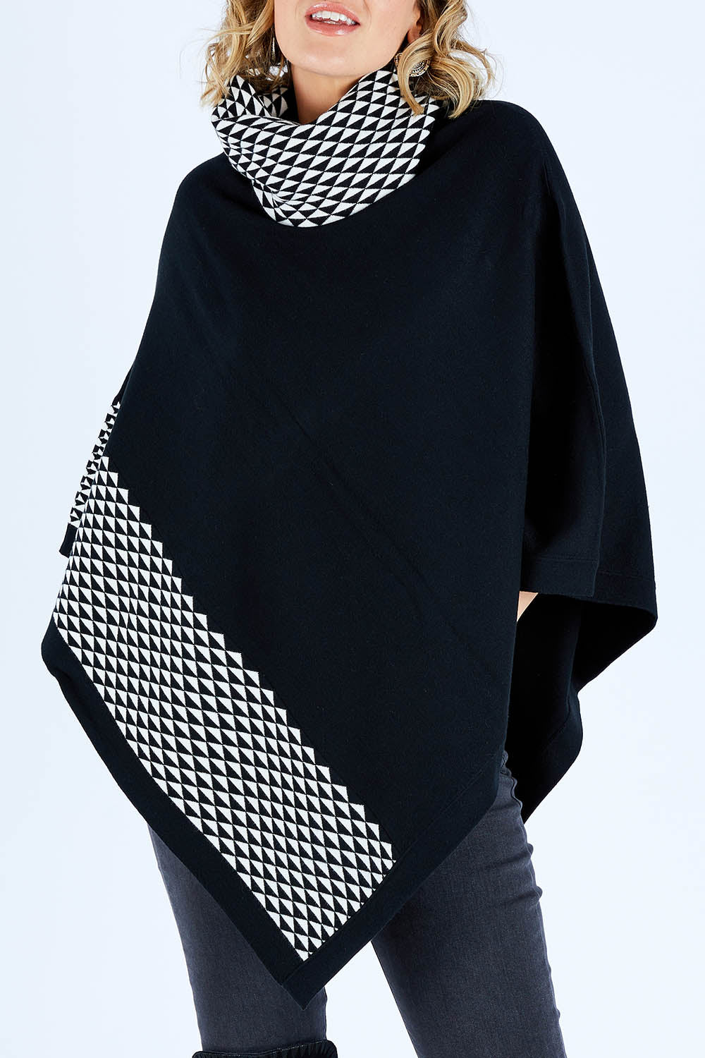 Model Chelsea wearing size S-M of The Patterned Removable Roll Neck Poncho in colour Blackprint (Black), from the front, cropped image