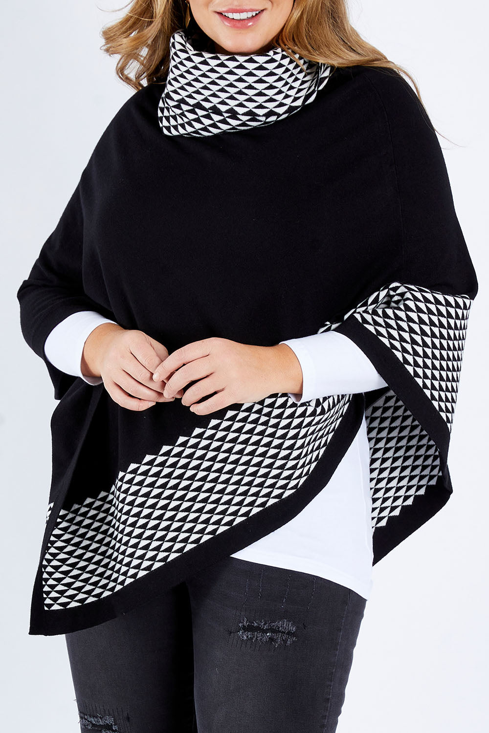 Model Fiona wearing size L-XL of The Patterned Removable Roll Neck Poncho in colour Blackprint (Black), from the front, cropped image