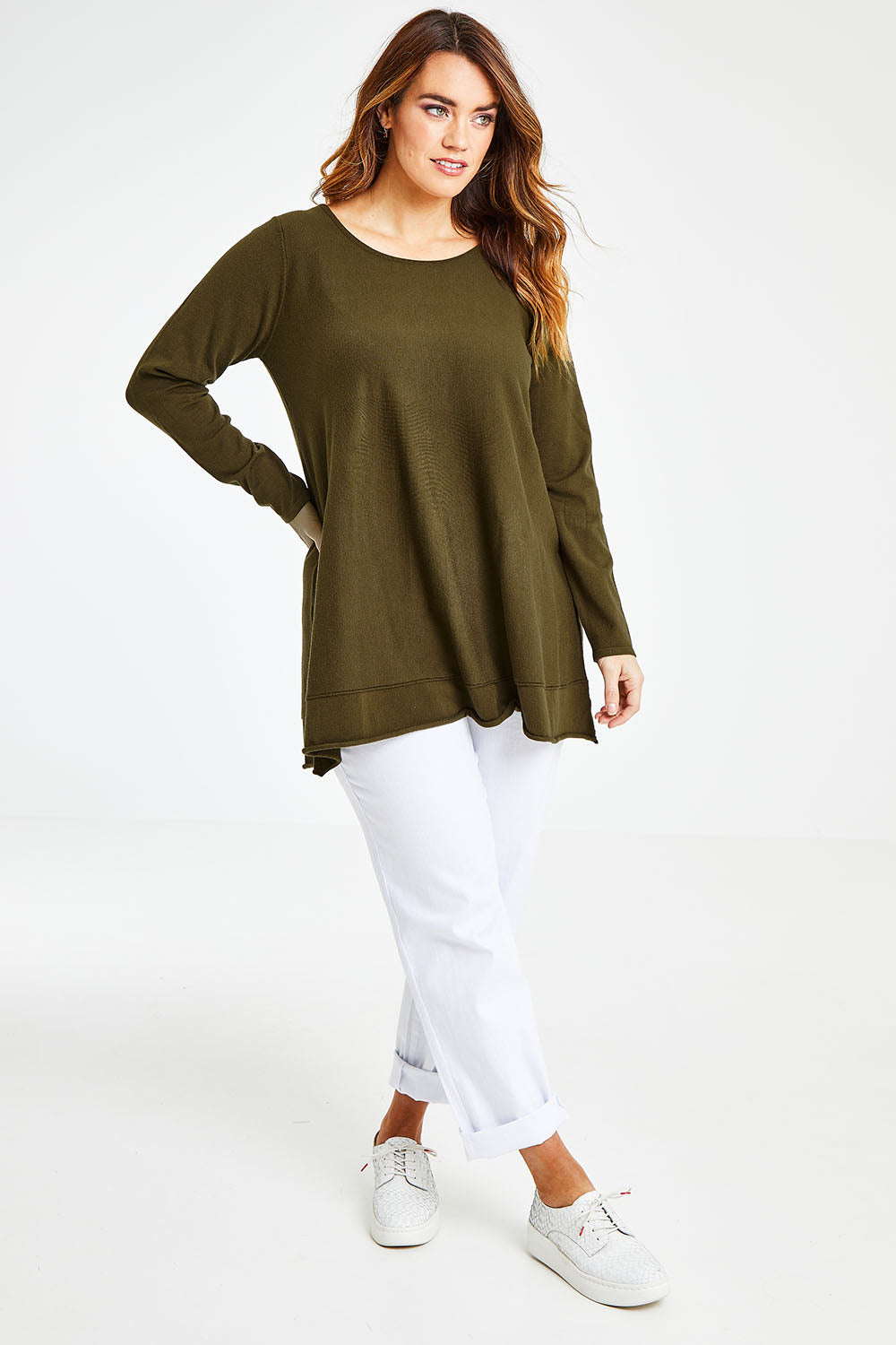 Model Laura wearing size L of The Swing Knit in colour Khaki (Green), from the front, showing the whole outfit