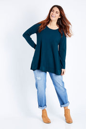 Model Laura wearing size M of The Swing Knit in colour Petrol (Blue), from the front, showing the whole outfit