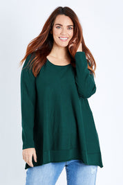 Model Laura wearing size M of The Swing Knit in colour Pinegreen (Green), from the front, cropped image