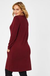 Model Jess wearing size L of The Pocket Detail Dress in colour Burgundy (Red), from the back
