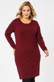 Model Jess wearing size L of The Pocket Detail Dress in colour Burgundy (Red), from the front, cropped image
