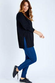 Model Laura wearing size L of The Side Split Tunic Top in colour Black (Black), from the front, showing the whole outfit