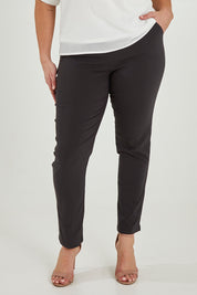 Model Maddy wearing size 16 of The Slim Cut Stretch Pant in colour Charcoal (Grey), from the front, cropped image