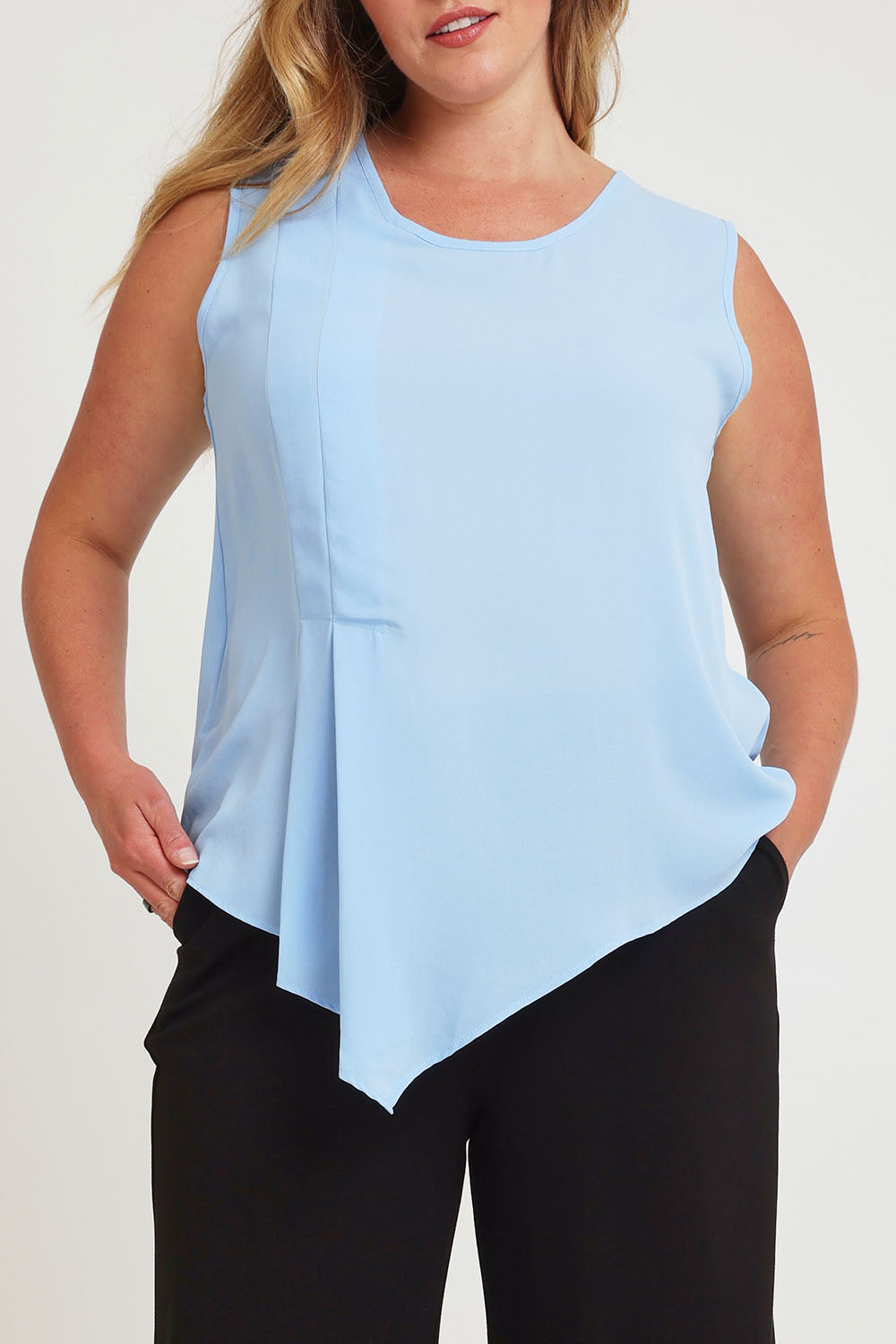 Model Chanel wearing size 16 of The Asymmetrical Tank Top in colour Sky (Blue), from the front, cropped image