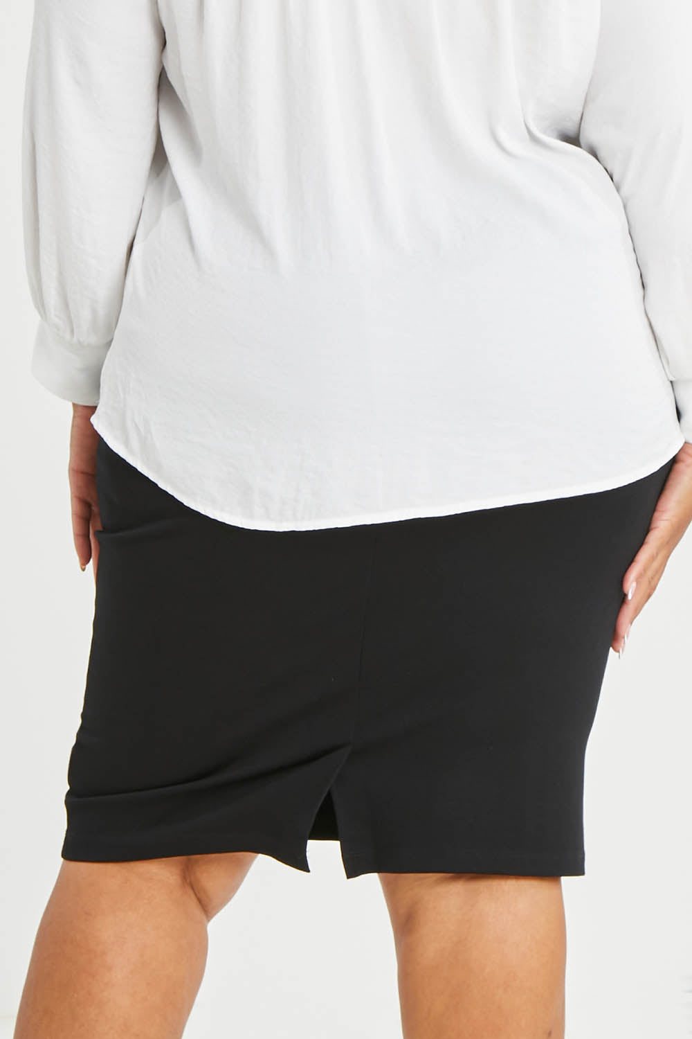 Model Alexis wearing size 16 of The Define Ponte Pull On Skirt in colour Black (Black), from the back