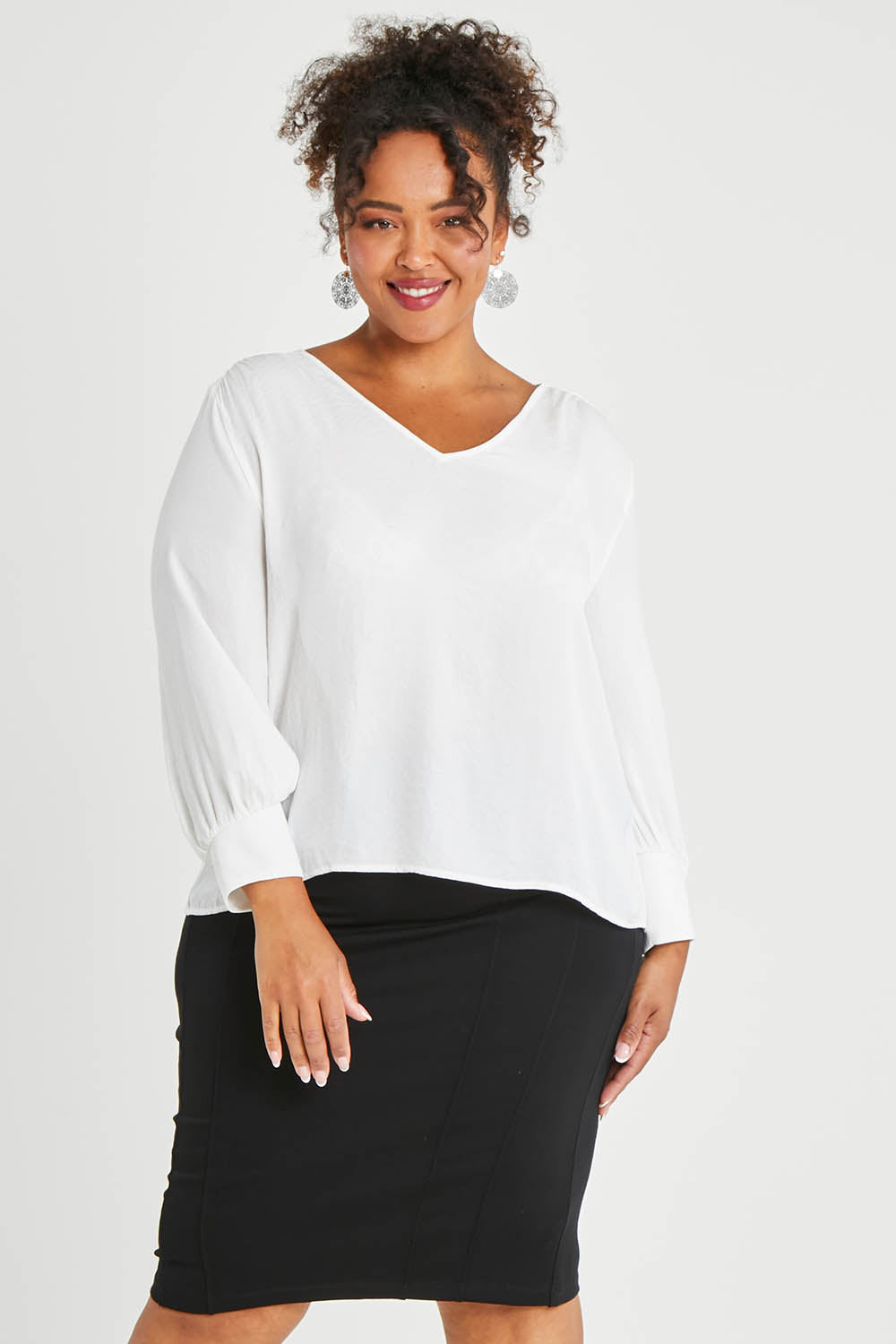 Model Alexis wearing size 16 of The Define Ponte Pull On Skirt in colour Black (Black), from the front, cropped image