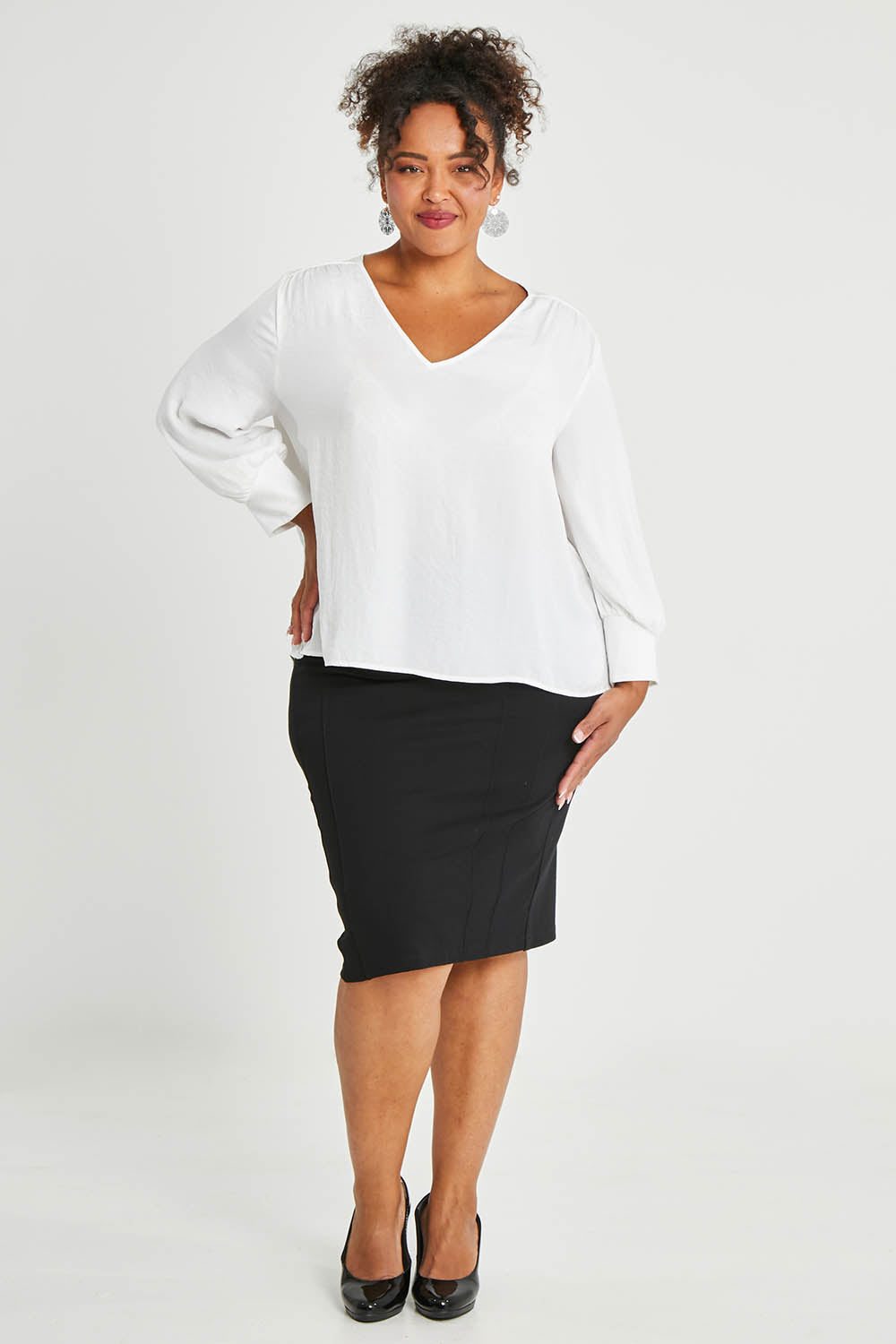 Model Alexis wearing size 16 of The Define Ponte Pull On Skirt in colour Black (Black), from the front, showing the whole outfit
