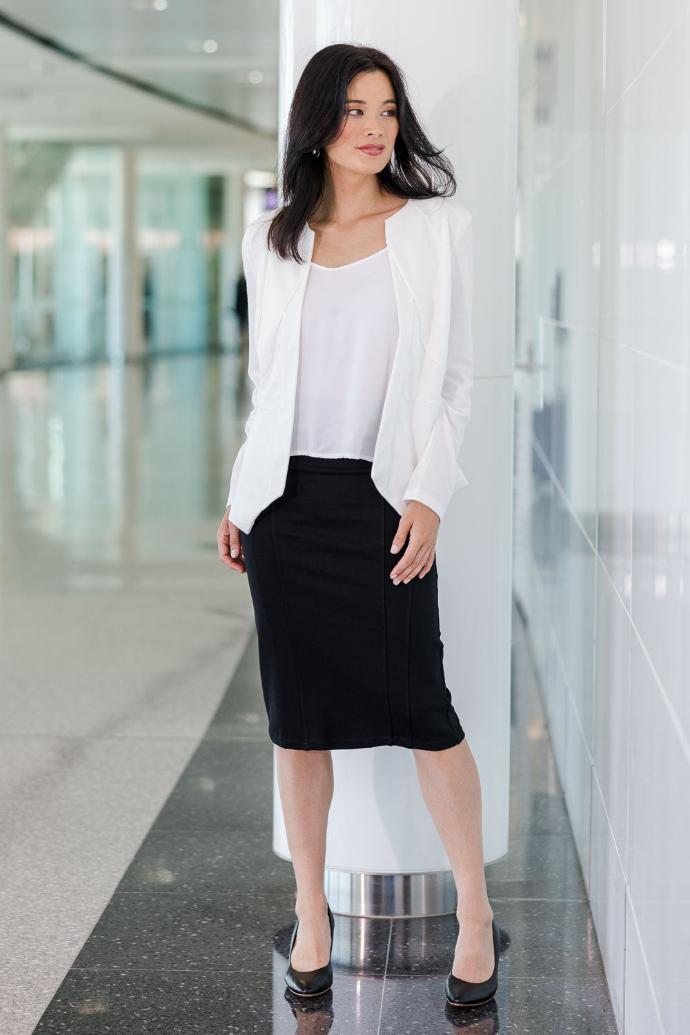 Model Miranda wearing size 10 of The Define Ponte Pull On Skirt in colour Black (Black), from the front, showing the whole outfit
