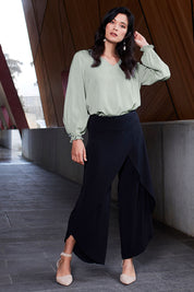 Model Miranda wearing size 10 of The Pleated Sleeve Top in colour Sage (Green), from the front, showing the whole outfit
